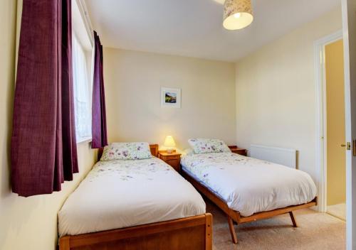1 dormitorio con 2 camas y ventana en Gainsborough en Torquay
