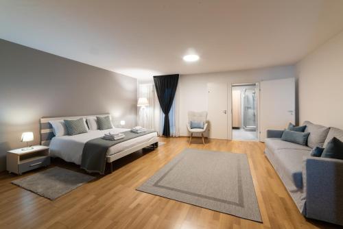 a bedroom with a bed and a couch at 76 The Lake House - Lugano in Melide
