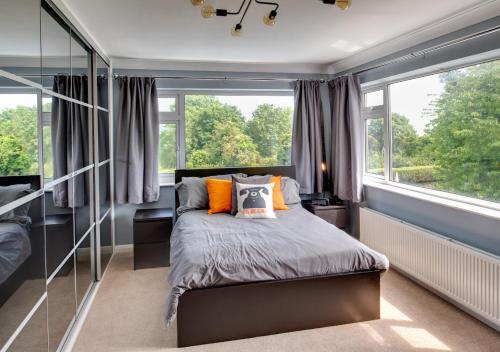 a bedroom with a bed and a large window at The Firs in Churston Ferrers