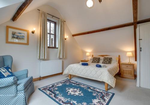 a bedroom with a bed and a couch and a chair at Luccombe Barn in Exminster