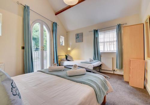 a bedroom with two beds and a window at Sunnyhill Mews in Torquay