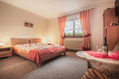 um quarto com uma cama, uma janela e uma mesa em Penzion Deny em Ždiar