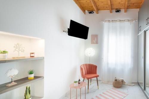 un soggiorno con sedia e TV di Anassa Hubs Two Bedroom Apartment 7 by Estia a Heraklion