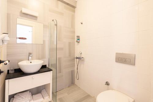 a white bathroom with a sink and a toilet at Bouti Ayvalık in Ayvalık