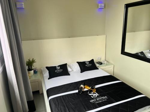 a bedroom with a bed with a black and white at Motel Hofim in Bat Yam