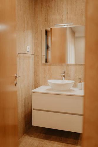 a bathroom with a white sink and a mirror at Antas Villa Family in Esposende