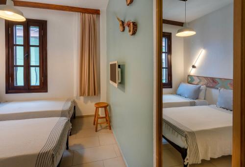 a hotel room with two beds and a couch at Bouti Ayvalık in Ayvalık