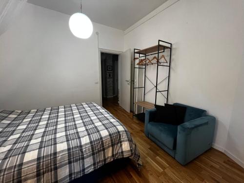 um quarto com uma cama e uma cadeira azul em Bianchelli Affittacamere em Iesi
