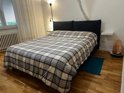 a bed with a checkered blanket in a bedroom at Bianchelli Affittacamere in Iesi