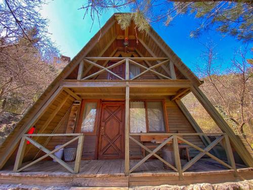 eine Hütte im Wald mit einer großen Holztür in der Unterkunft Antik Vadi Bungalow in Edremit