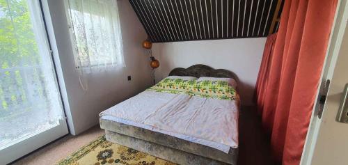a small bed in a room with a window at Apartment in Balatonbereny 35891 in Balatonberény