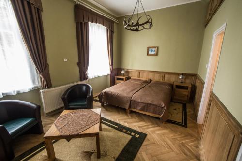 a bedroom with a bed and a chair and a table at Zsitfapusztai Vadászház in Vizvár