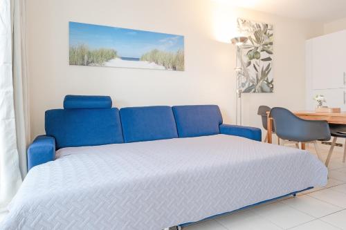 ein blaues Bett in einem Zimmer mit einem Schreibtisch in der Unterkunft Strandvilla 27, Turmwohnung in Scharbeutz