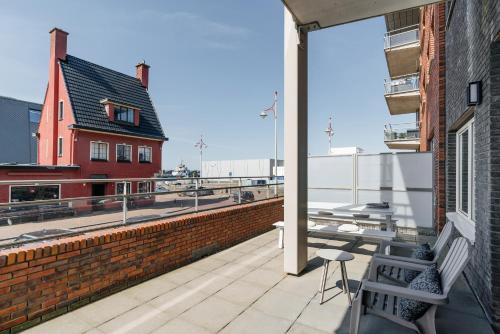uma varanda com um banco e vista para um edifício em BizStay Harbour IV em Scheveningen
