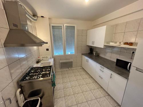 uma pequena cozinha com um fogão e um lavatório em Best holliday Home for family newly renovated em Garges-lès-Gonesse