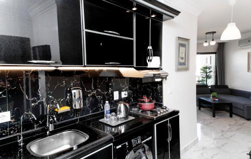 una cocina con armarios negros y fregadero en Porto Said Tourist Resort Luxury Hotel Apartment, en Puerto Saíd