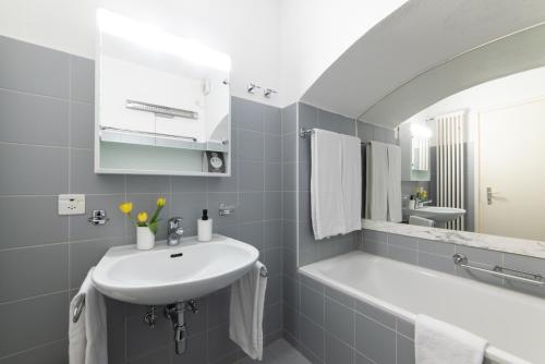 een badkamer met een wastafel en een bad bij 76 The Lake House - Lugano in Melide