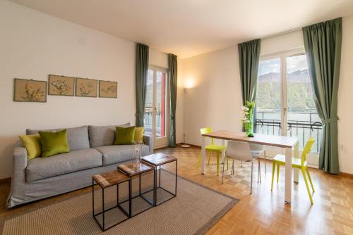 ein Wohnzimmer mit einem Sofa und einem Tisch in der Unterkunft 76 The Lake House - Lugano in Melide