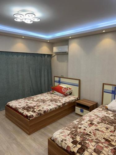 1 Schlafzimmer mit 2 Betten und einer Decke in der Unterkunft شقة للايجار في الزمالك in Kairo