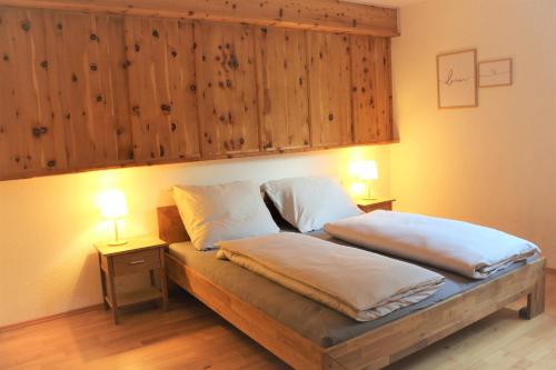 1 dormitorio con 1 cama con 2 almohadas y 2 lámparas en Ferienwohnung am Einödhof, en Uttendorf