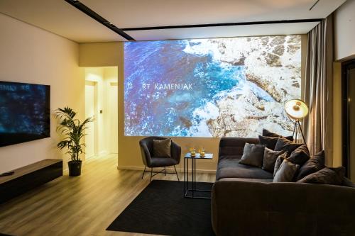 um grande ecrã numa sala de estar com um sofá em Villa Aida - 4 bedroom luxury villa with large private pool 4K projector and Jacuzzi em Pula