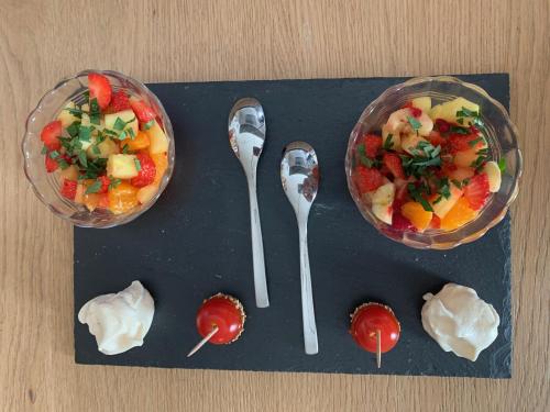 een groep lepels met fruit en yoghurt op een tafel bij Chambre d'Hôtes Les Petits Oiseaux in Nantes