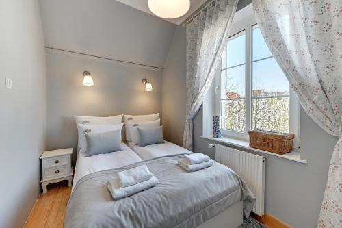 a bedroom with a bed and a window at Downtown Apartments Old Town Długa Vintage in Gdańsk