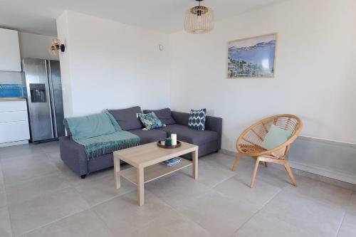 un salon avec un canapé, une table et une chaise dans l'établissement Spacious T4 with sea and Esterel views, à Saint-Raphaël