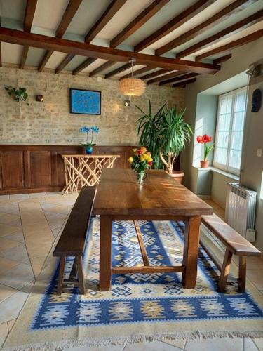 - une table et un banc en bois dans le salon dans l'établissement Chambres d'hôtes de charme entre Bayeux et les plages du débarquement, à Sommervieu