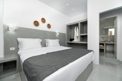 a white bedroom with a large bed in a room at Aerenia Luxury Suites in Karterados