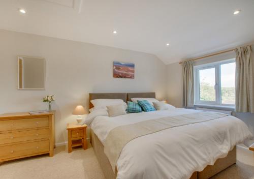 a bedroom with two beds and a window at Valley View in Colyton