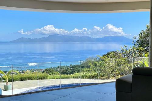 uma sala de estar com vista para a água em Villa Menemene one of a kind place in Tahiti em Punaauia