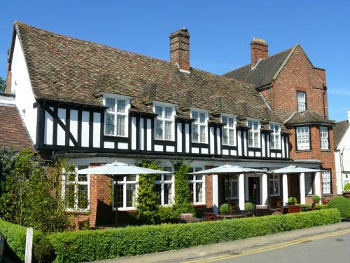 een groot bakstenen gebouw met parasols ervoor bij The George Hotel in Buckden