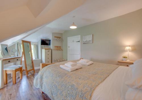 a bedroom with a large bed with two towels on it at Otters Corner in Branscombe