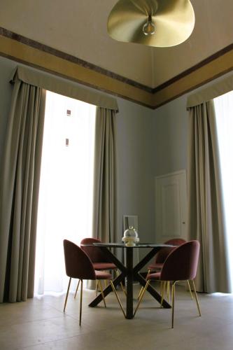 a dining room with a black table and chairs at Palazzo sul Corso-Charming Appartaments in Brindisi