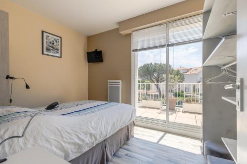 a bedroom with a bed and a large window at L'Hollywood Zen in Saint-Jean-de-Monts