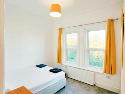 a bedroom with a bed and two windows at C-New Flat,4 Adults,20 mins to Beach,Netflix,Wifi in Bournemouth