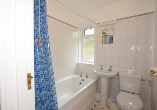 a bathroom with a toilet and a tub and a sink at Purley in Beer