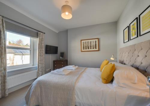 - une chambre avec un grand lit et une fenêtre dans l'établissement Victoria Cottage, à Beer