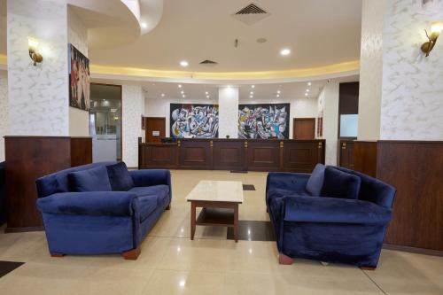 a waiting room with two blue chairs and a table at Hotel Continental in Golden Sands