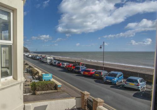 a line of cars parked next to the beach at Brixham View in Seaton