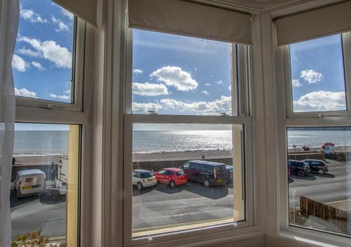 a room with windows looking out at the beach at Brixham View in Seaton