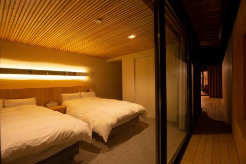 1 dormitorio con 2 camas y espejo en 美都津山庵別邸 Lb1 en Tuyama