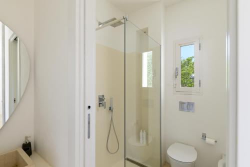 uma casa de banho com uma cabina de duche em vidro e um WC. em Villa La Guaceta by Wonderful Italy em Carovigno