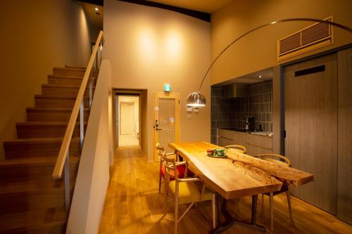un comedor con una mesa de madera y una escalera en 美都津山庵別邸 Lb1 en Tuyama