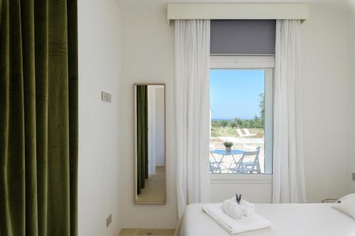 um quarto com uma cama, um espelho e uma mesa em Villa La Guaceta by Wonderful Italy em Carovigno
