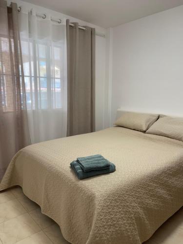 - une chambre avec un lit et une serviette dans l'établissement PLAYA SUR (piscina y mar), à Dénia