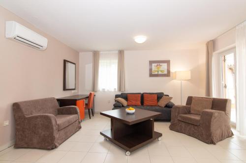 uma sala de estar com um sofá, cadeiras e uma mesa em Lebic 411 in Marina Portoroz by Locap Group em Portorož