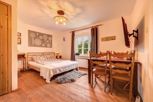 - une chambre avec un lit, une table et des chaises dans l'établissement Uroczysko Skomackie, à Stare Juchy