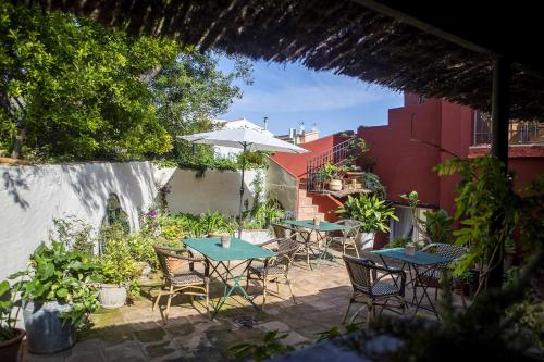 a patio with tables and chairs and an umbrella at unic views begur, alojamiento turístico in Begur